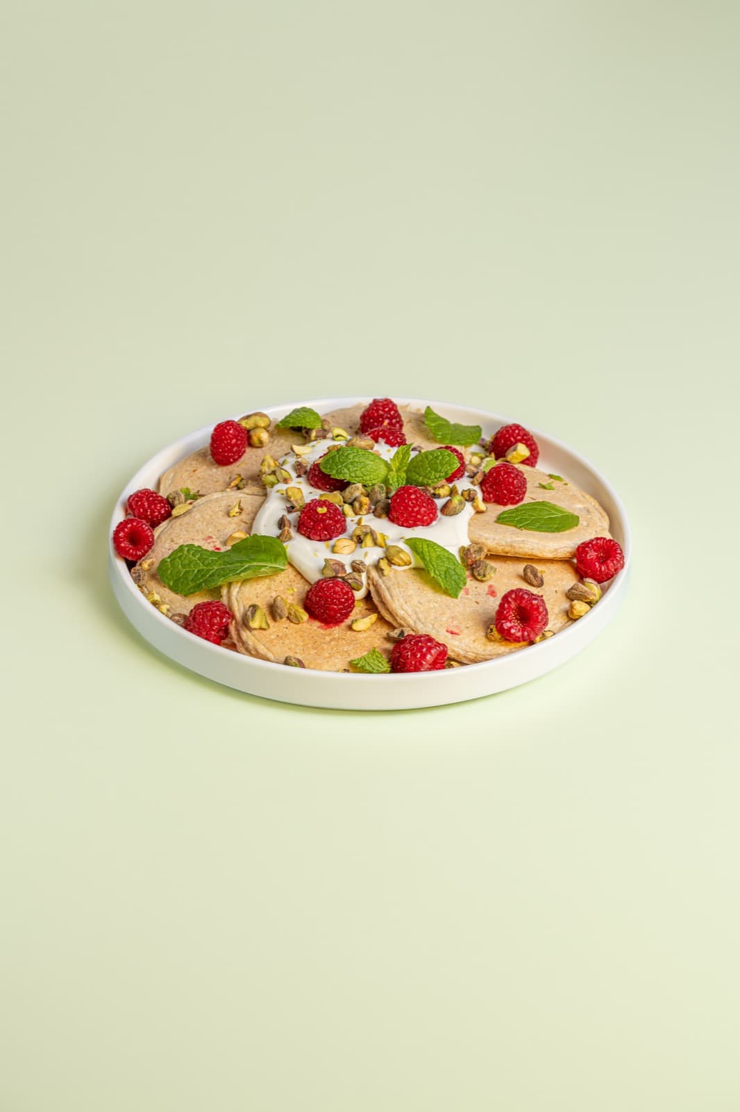 Placki z malinami, kremem, pistacjami i miętą